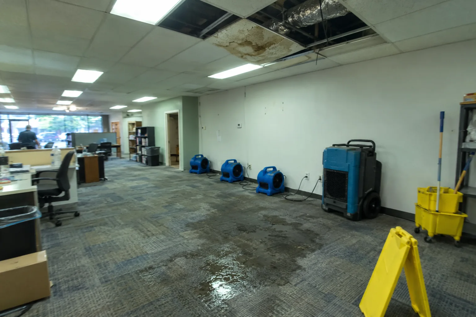Water-damaged commercial office with removed ceiling tiles and drying equipment in Smyrna